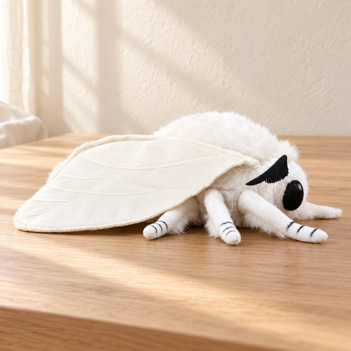 Vesper Snow - 25 cm moth and insect plush on a pale oak table