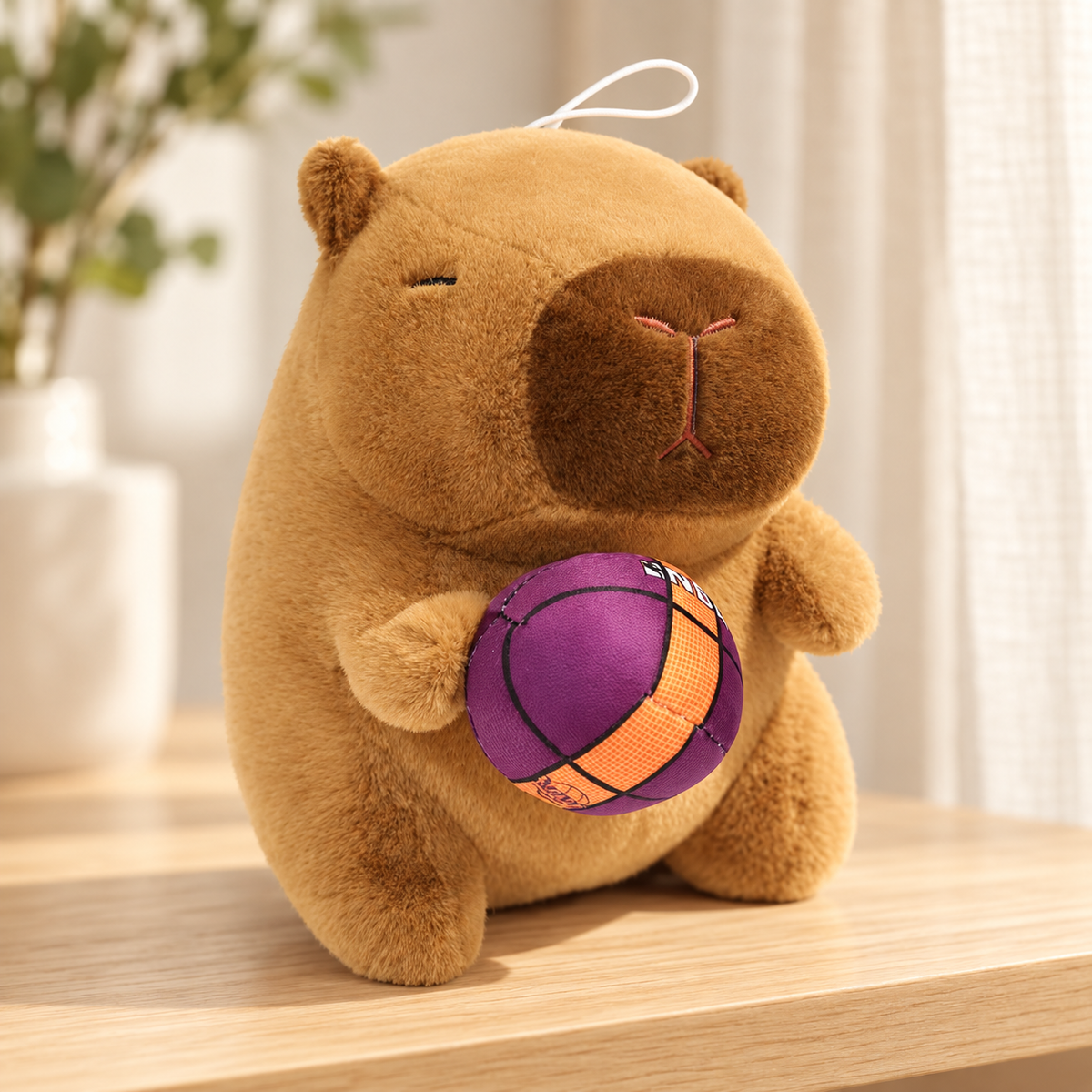 Marlow capybara plush, 25 cm, holding a purple and orange basketball.