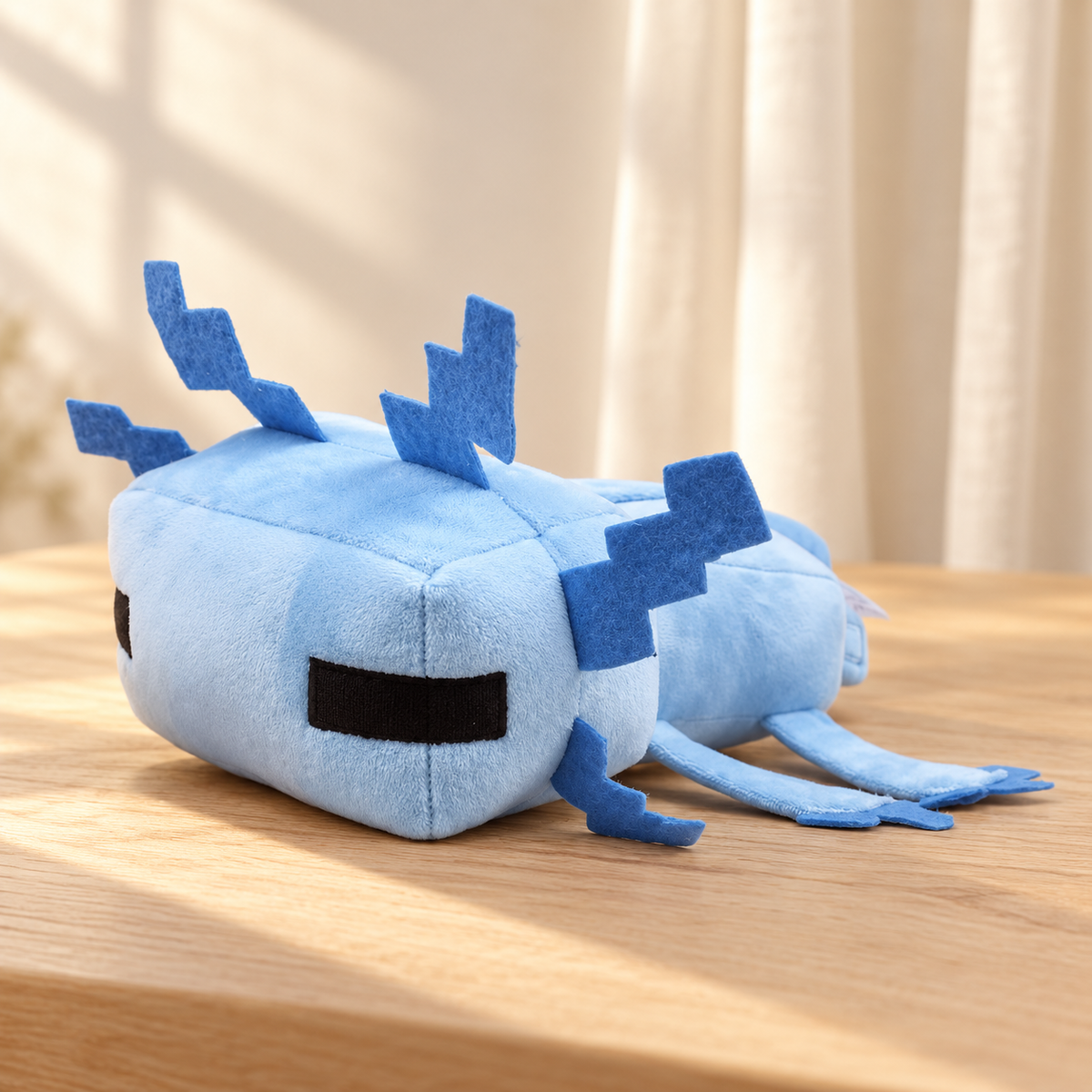 Blue Pixie axolotl plush, 30 cm, photographed alone on a pale oak table