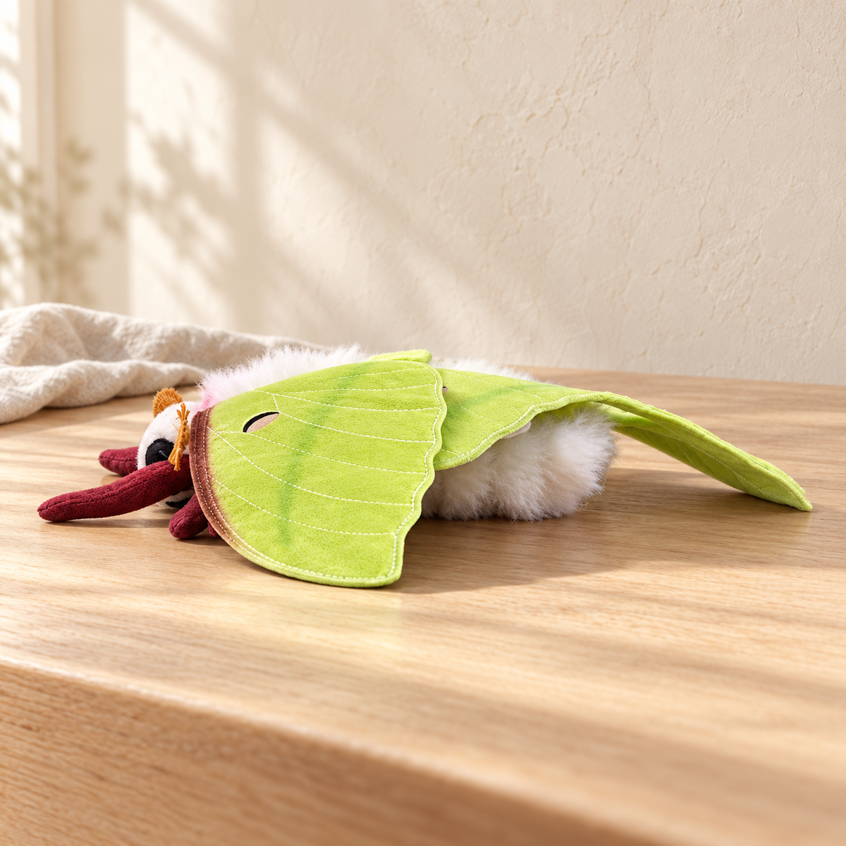 Vesper Leaf Green - 22 cm moth and insect plush on a pale oak table